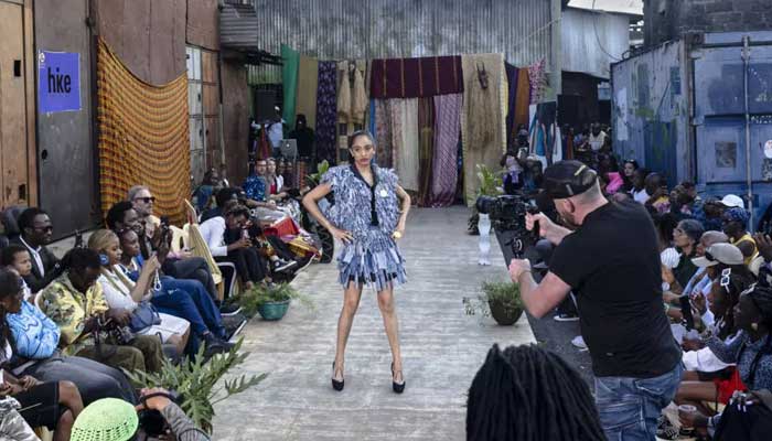 Models show off outfits created by local fashion designers specialising in upcycling discarded fabrics and garments from second-hand clothes markets. — AFP