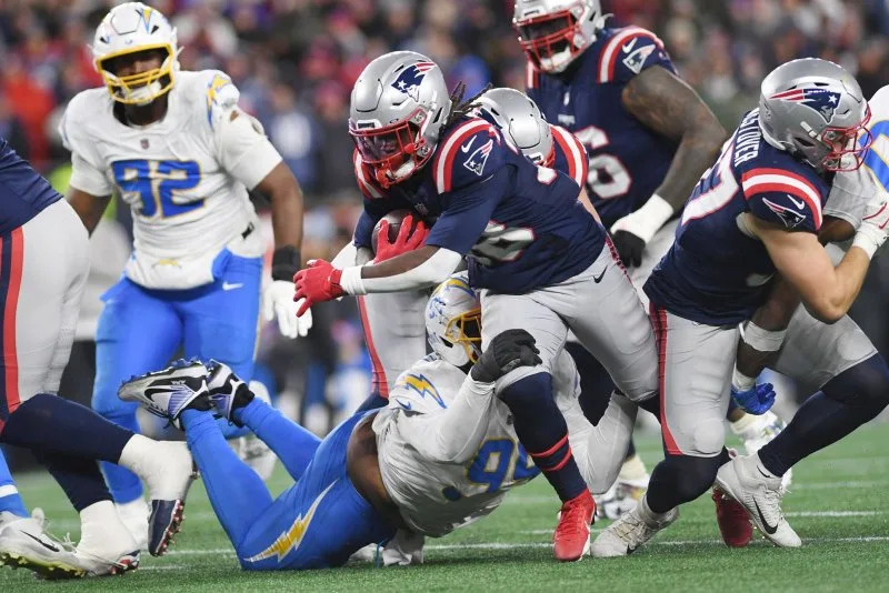 New England Patriots running back Rhamondre Stevenson (38) is tackled by Los Angeles Chargers linebacker Tuli Tuipulotu (45) after a gain of 5 yards in the third quarter of an NFL wild card playoff game Sunday at Gillette Stadium in Foxborough, Mass. Photo by Amanda Sabga/UPI